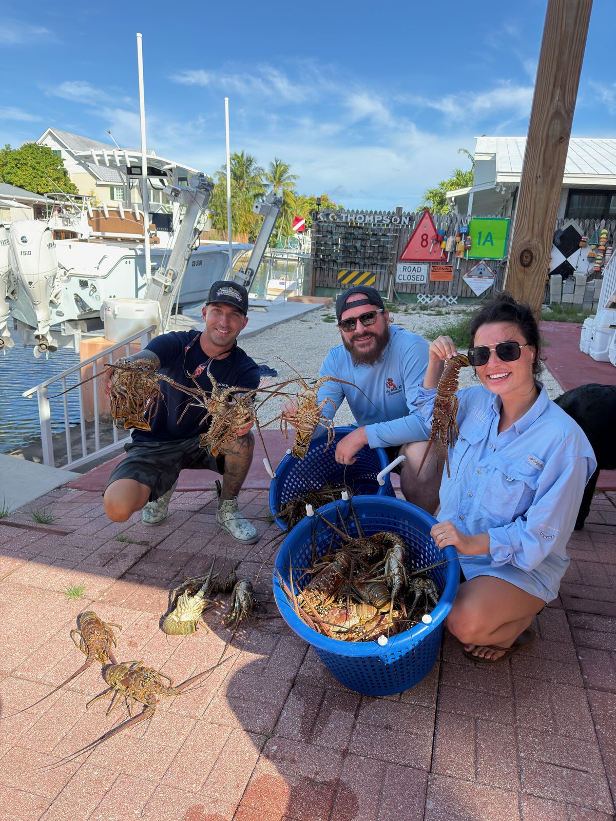 Crew kneeling at the dock with baskets full of Florida spiny lobster
